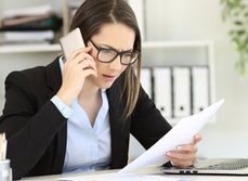 Une femme au visage inquiète est au téléphone et tient un document dans l'autre main - MACSF